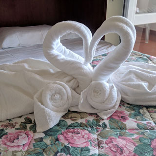 Composizione di benvenuto con asciugamani sul letto