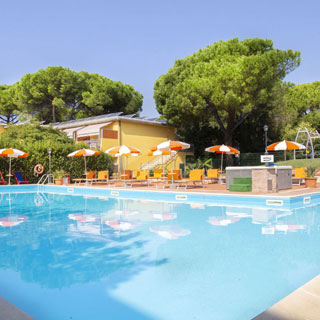 Piscina con solarium e area giochi sullo sfondo